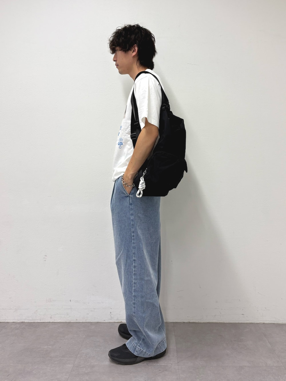 ホワイト系のTシャツ/カットソー、ブラック系のバックパック/リュック、ブルー系のデニムパンツを着用したメンズの夏コーディネートの2枚目の写真