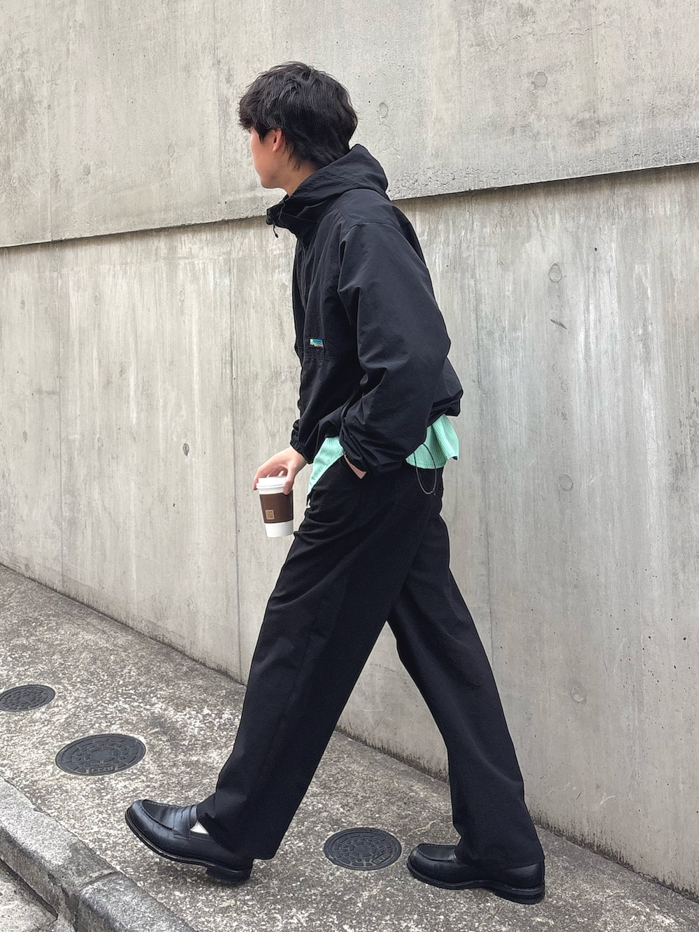 ブラック系のマウンテンパーカー、グリーン系のシャツ/ブラウス、ブラック系のその他パンツを着用したメンズの春コーディネートの2枚目の写真