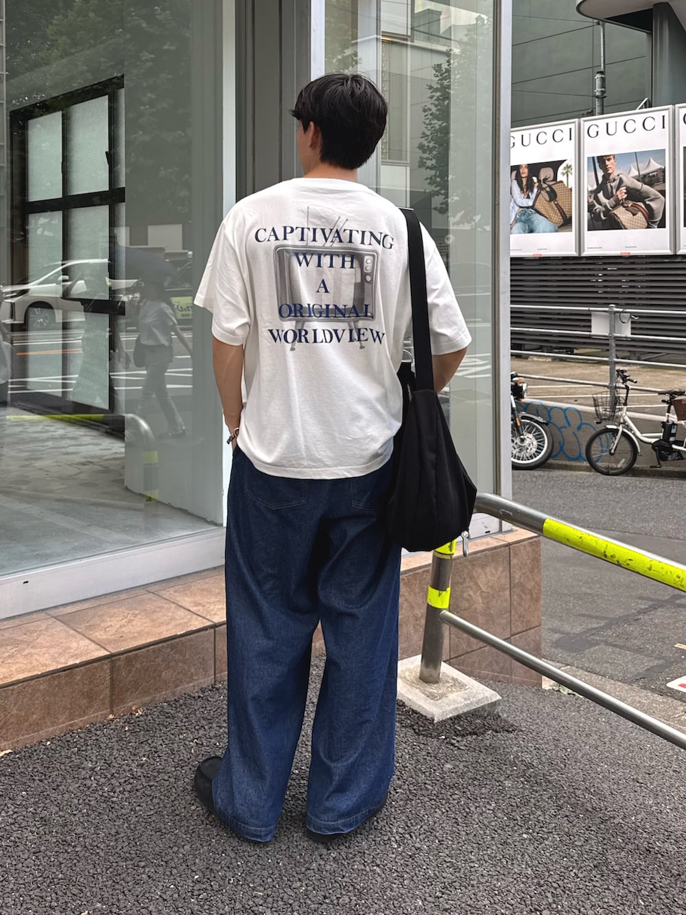 ホワイト系のTシャツ/カットソー、ブラック系のショルダーバッグ、ブルー系のデニムパンツを着用したメンズの夏コーディネートの2枚目の写真