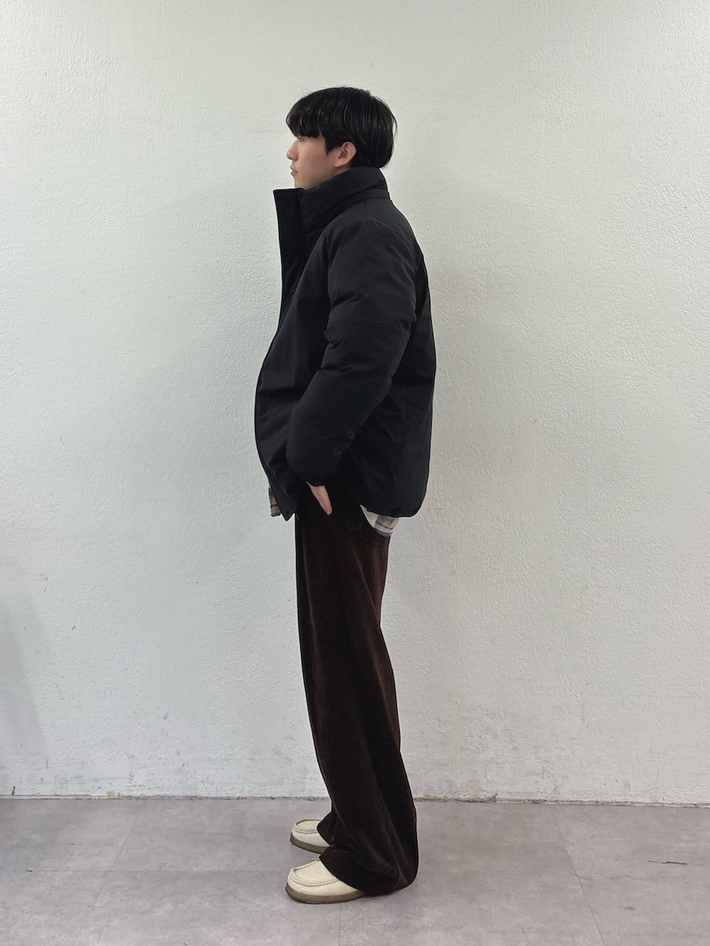 ブラック系のダウンジャケット/コート、ベージュ系のシャツ/ブラウス、ブラック系のその他パンツを着用したメンズの冬コーディネートの2枚目の写真