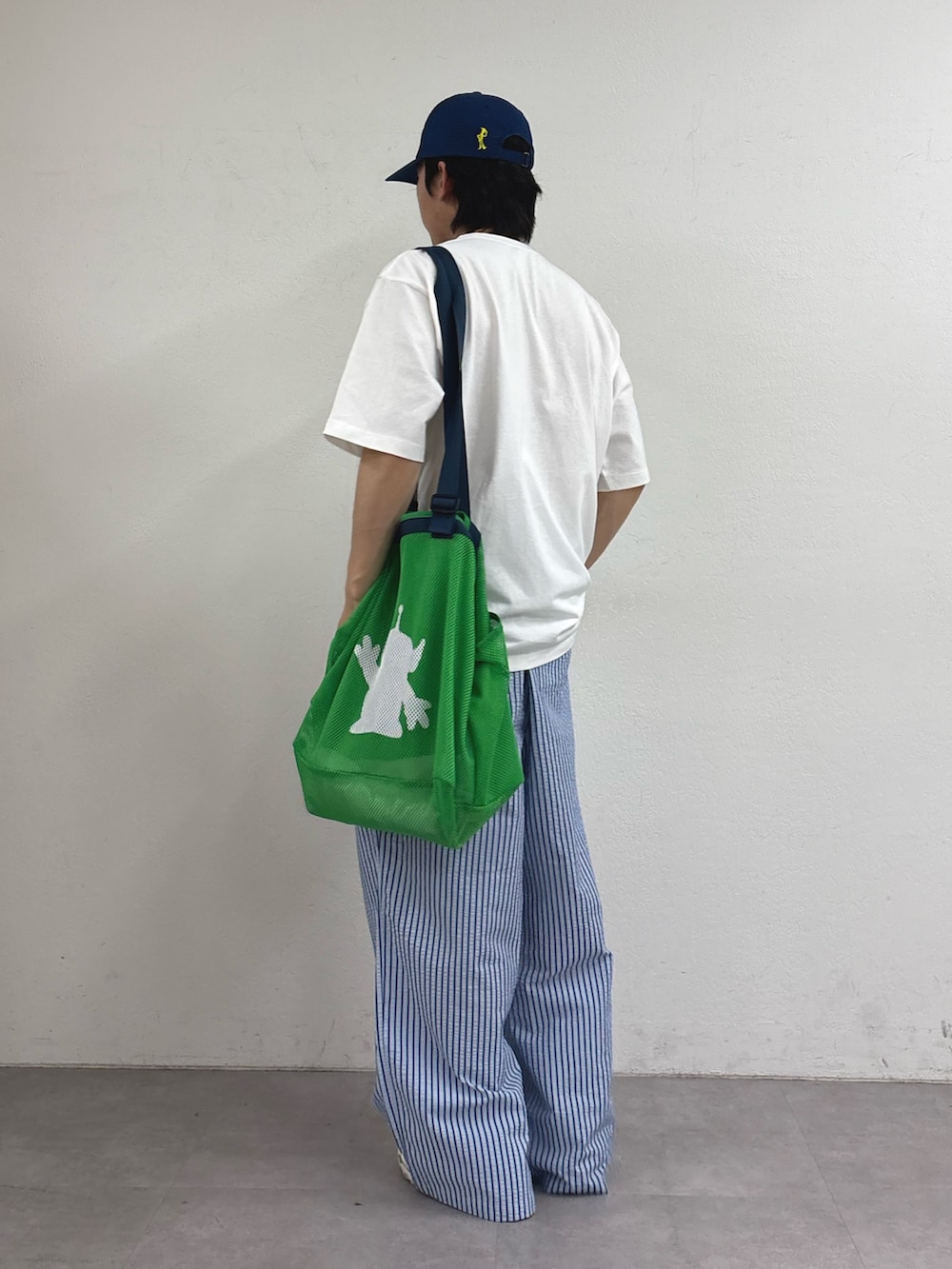 グリーン系のトートバッグ、ホワイト系のTシャツ/カットソー、ブルー系のその他パンツを着用したメンズの春コーディネートの3枚目の写真
