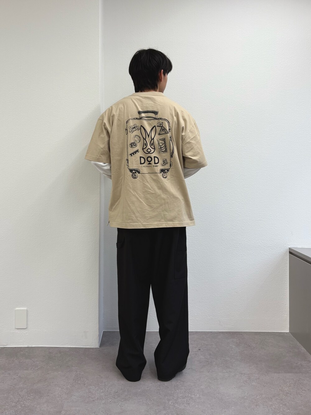 ベージュ系のTシャツ/カットソー、ブラック系のスラックスを着用したメンズの春コーディネートの3枚目の写真