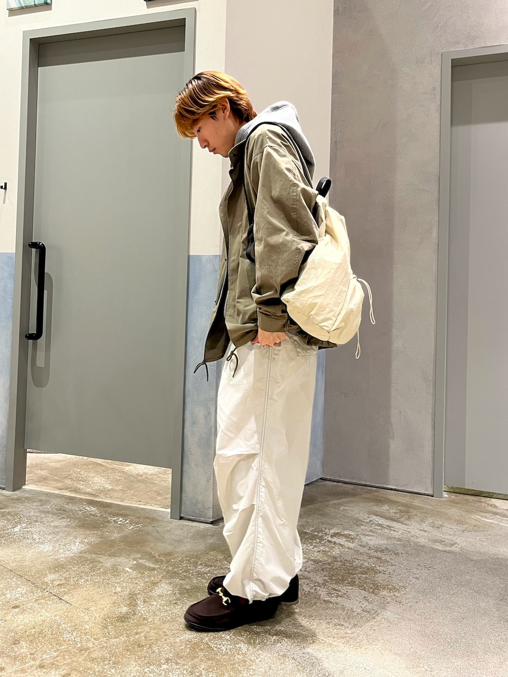 ブラウン系のローファー、グレー系のカーゴパンツ、グリーン系のMA-1を着用したメンズの冬コーディネートの2枚目の写真