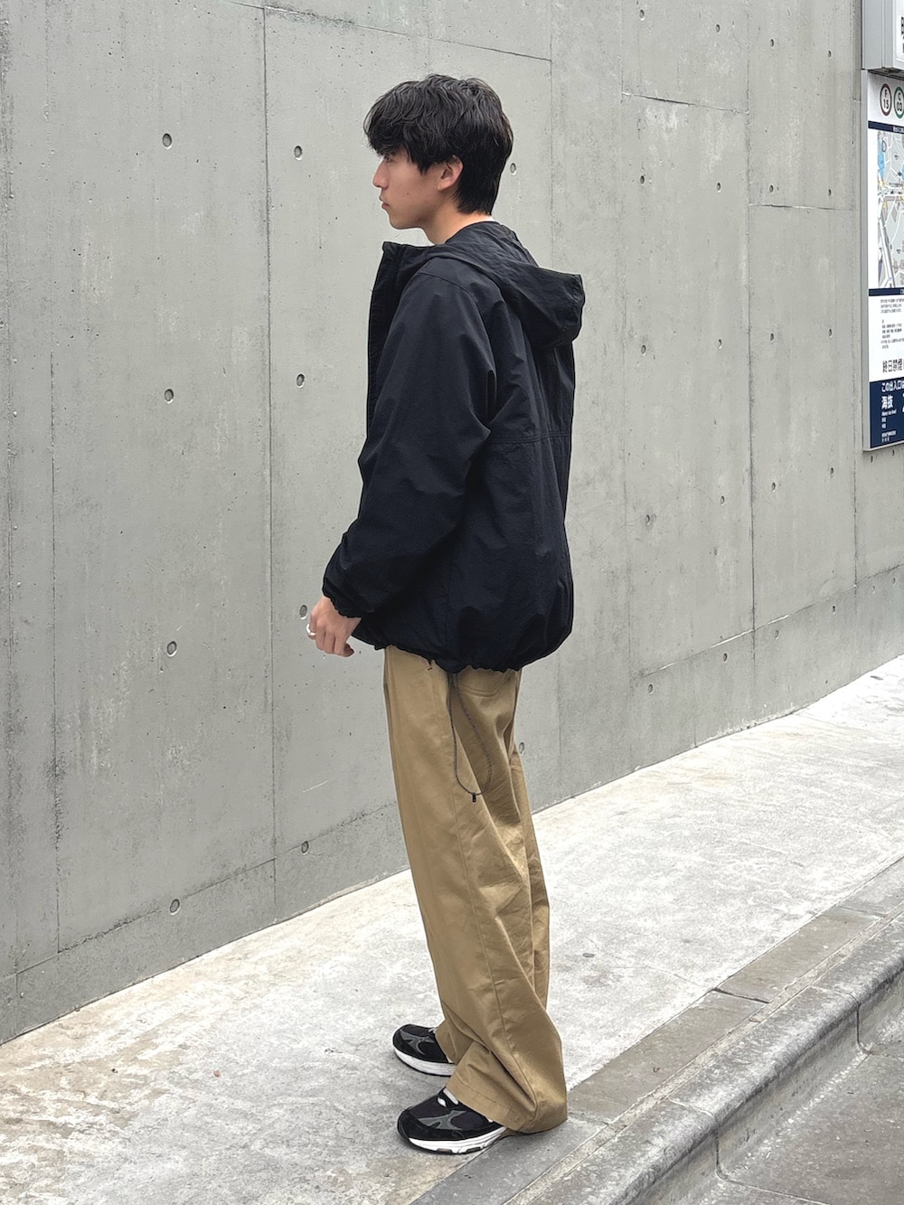 ブラック系のパーカー、ブラック系のTシャツ/カットソー、ベージュ系のデニムパンツを着用したメンズの春コーディネートの2枚目の写真