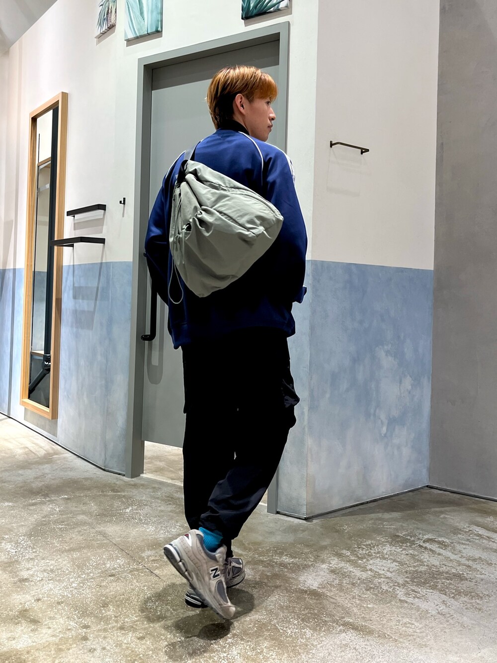 ブルー系のジャージ、ブラック系のカーゴパンツ、グレー系のスニーカーを着用したメンズの秋コーディネートの2枚目の写真