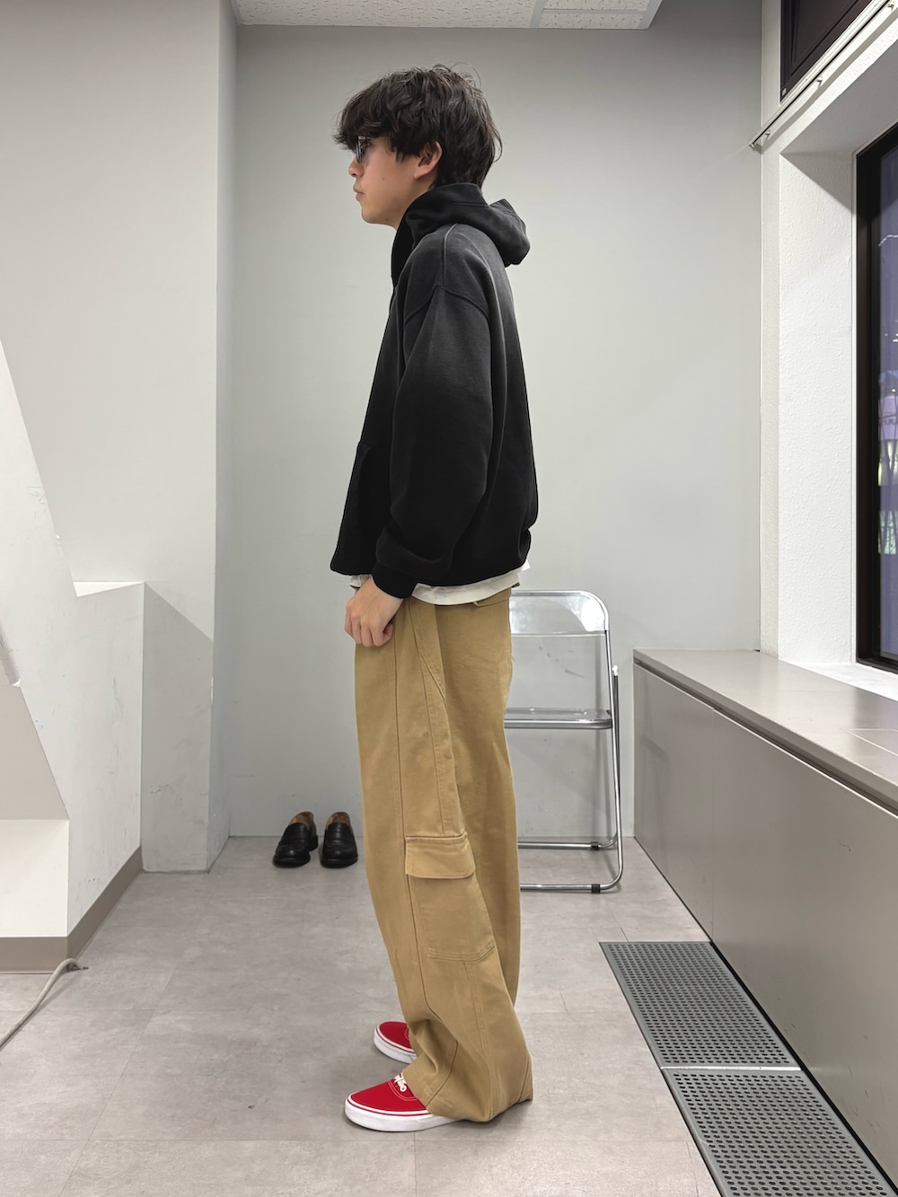 ブラック系のパーカー、ベージュ系のカーゴパンツを着用したメンズの冬コーディネートの2枚目の写真