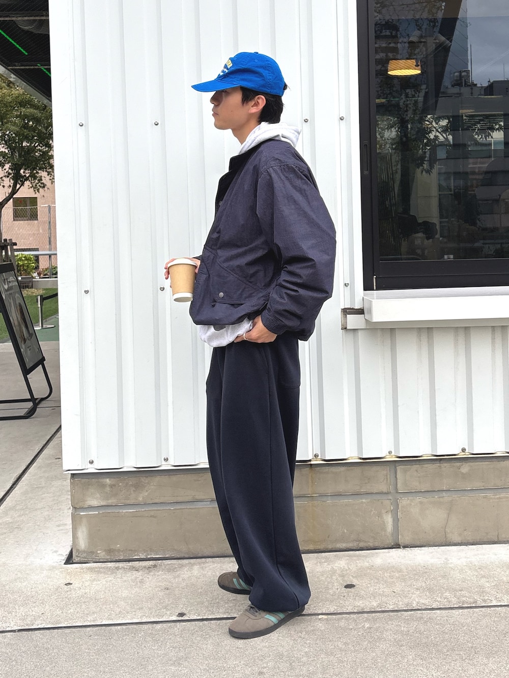 ブルー系のナイロンジャケット、グレー系のパーカーを着用したメンズの秋コーディネートの2枚目の写真