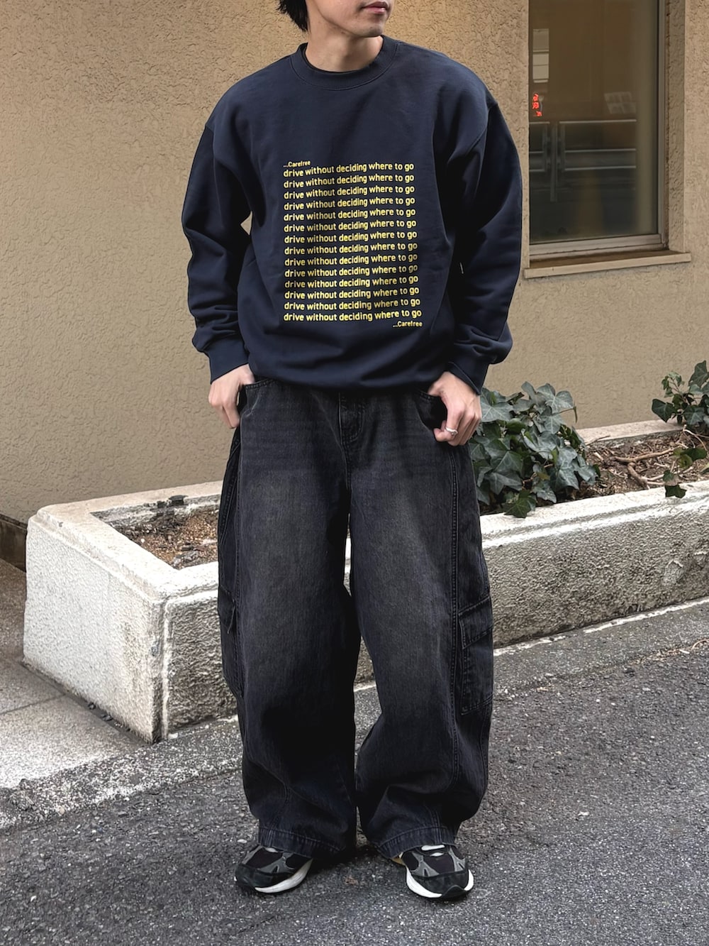 イエロー系のスウェット、ブラック系のカーゴパンツを着用したメンズの冬コーディネートの2枚目の写真