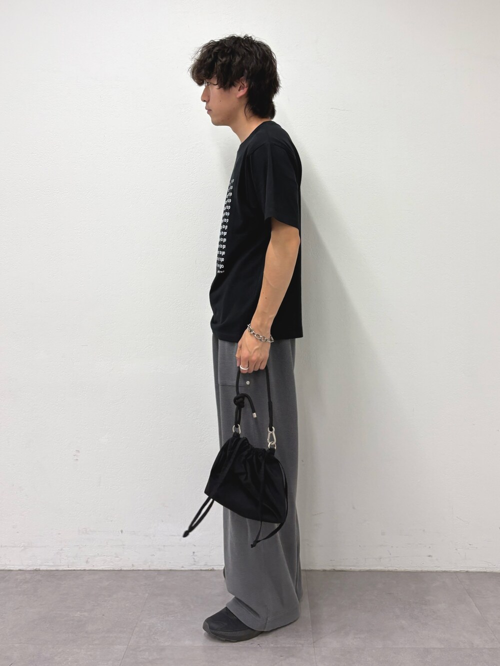 ブラック系のTシャツ/カットソー、グレー系のスウェットパンツ、ブラック系のショルダーバッグを着用したメンズの夏コーディネートの2枚目の写真