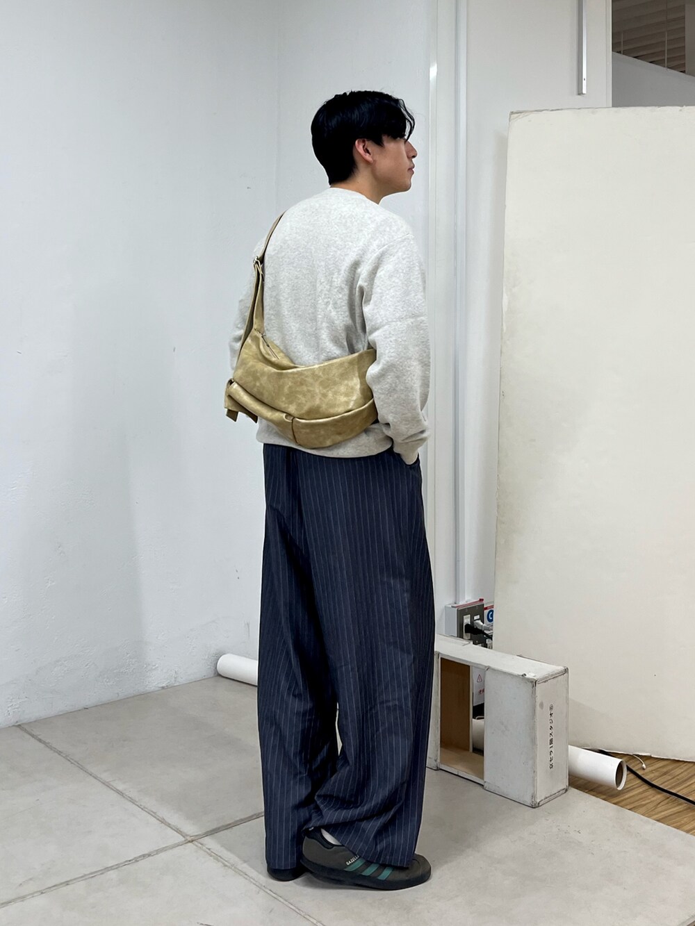 グレー系のスラックス、グレー系のスニーカー、グレー系のスウェットを着用したメンズの秋コーディネートの2枚目の写真