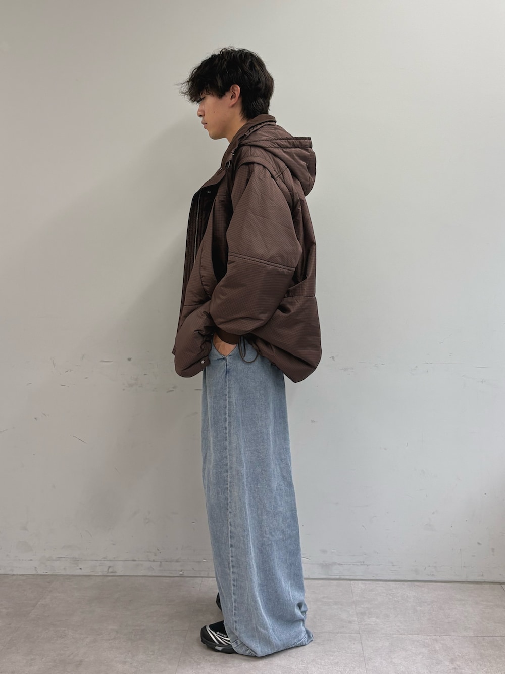 ブラウン系のモッズコート、グレー系のTシャツ/カットソー、ブルー系のデニムパンツを着用したメンズの秋コーディネートの2枚目の写真