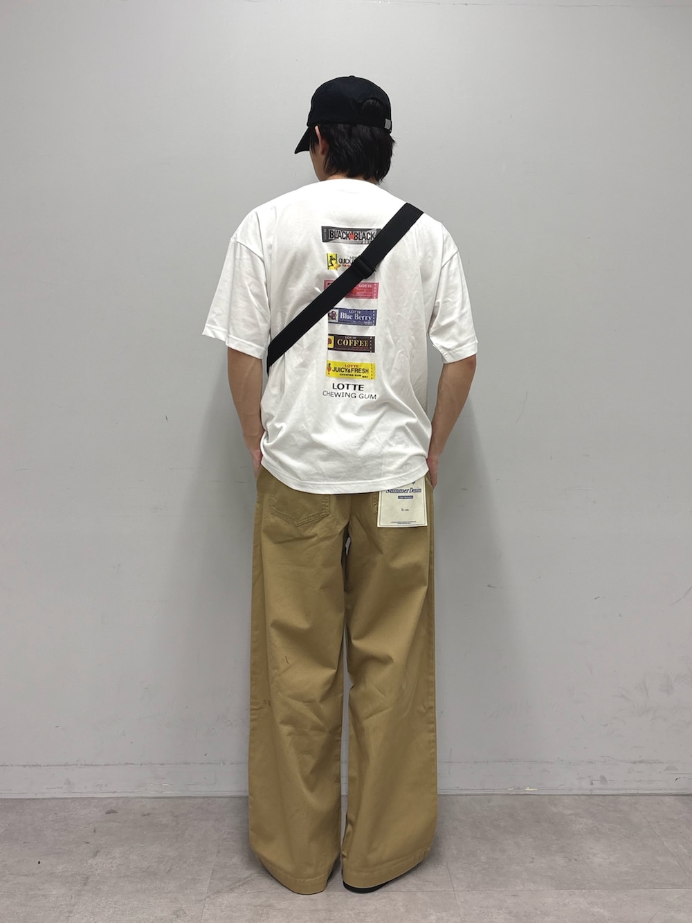 ホワイト系のTシャツ/カットソー、ブラック系のボディバッグ/ウエストポーチ、ベージュ系のデニムパンツを着用したメンズの春コーディネートの3枚目の写真