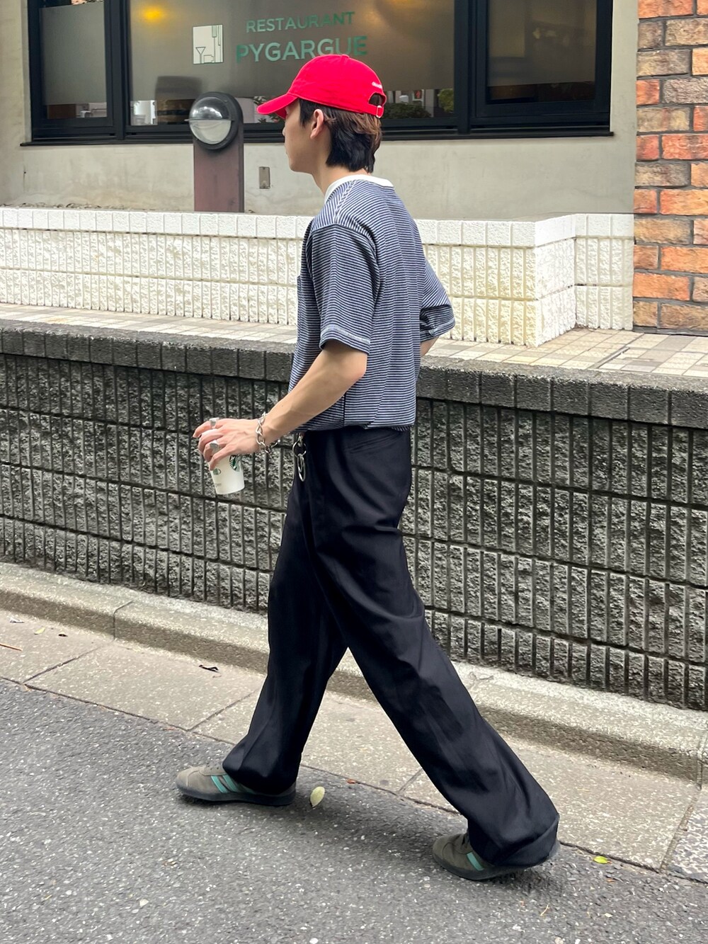 ブルー系のTシャツ/カットソー、ブラック系のスラックス、グレー系のスニーカーを着用したメンズの夏コーディネートの3枚目の写真