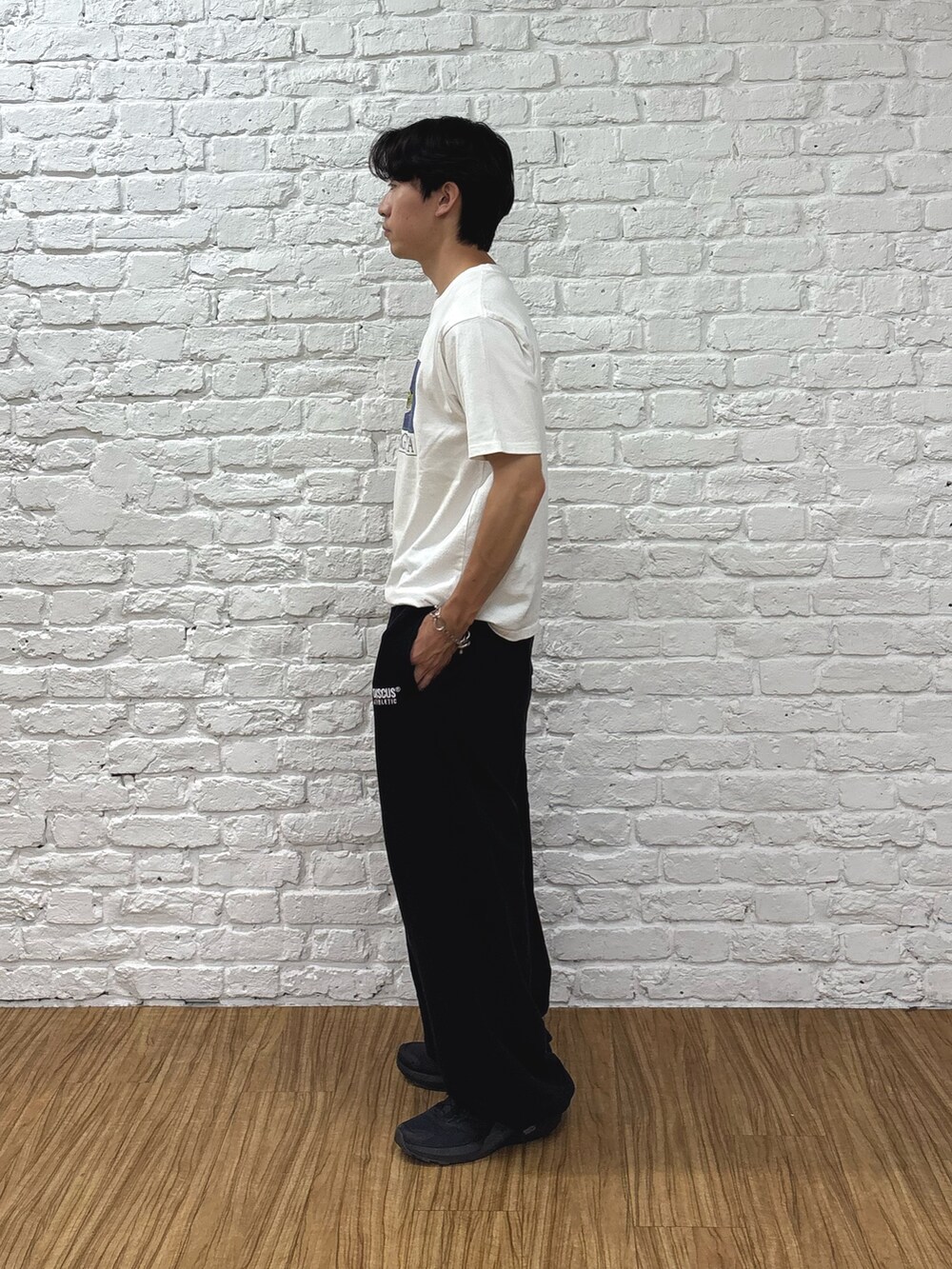 ホワイト系のTシャツ/カットソー、ブラック系のスウェットパンツ、ブラック系のトートバッグを着用したメンズの夏コーディネートの2枚目の写真