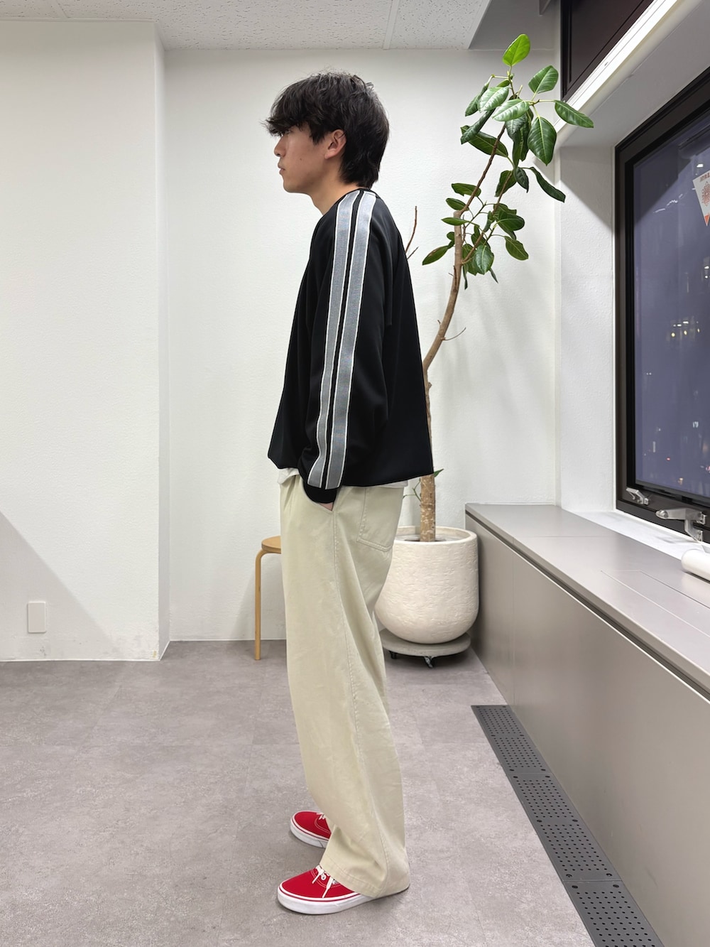 ブラック系のスウェット、ホワイト系のチノパンツを着用したメンズの冬コーディネートの2枚目の写真