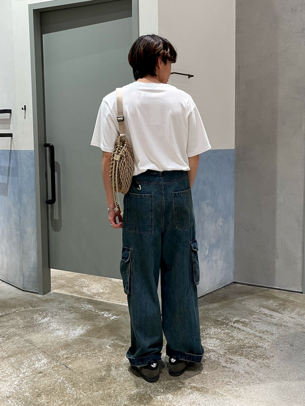 ブルー系のカーゴパンツ、グレー系のスニーカー、ホワイト系のTシャツ/カットソーを着用したメンズの夏コーディネートの3枚目の写真