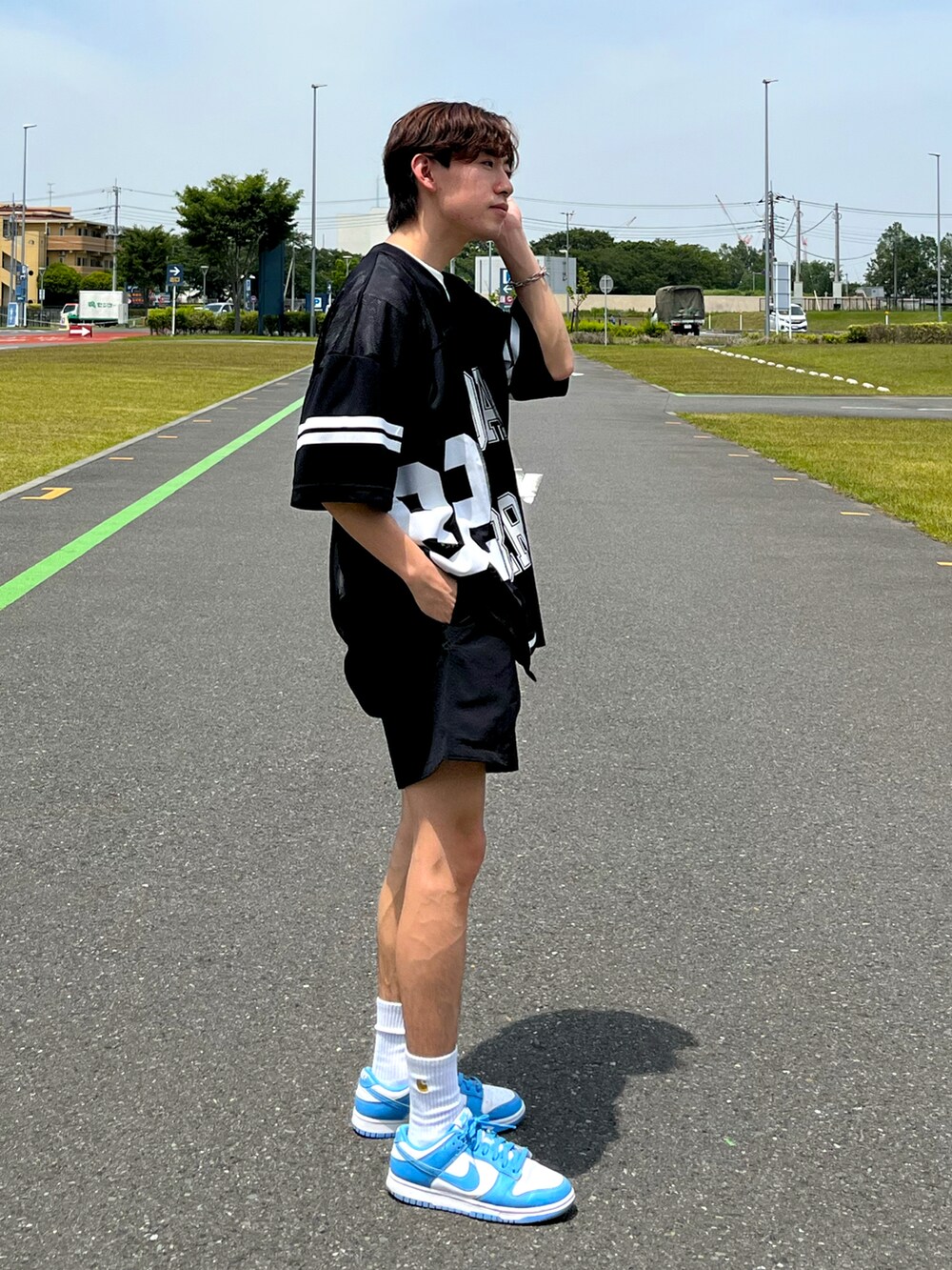 ブルー系のスニーカー、ホワイト系のトップス、ブラック系のTシャツ/カットソーを着用したメンズの夏コーディネートの2枚目の写真