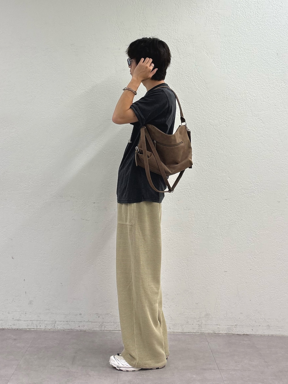 ブラック系のTシャツ/カットソー、ベージュ系のショルダーバッグ、ベージュ系のスウェットパンツを着用したメンズの夏コーディネートの2枚目の写真