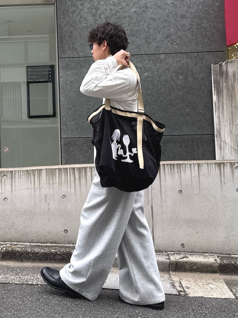 グレー系のTシャツ/カットソー、ブラック系のトートバッグを着用したメンズの春コーディネートの2枚目の写真
