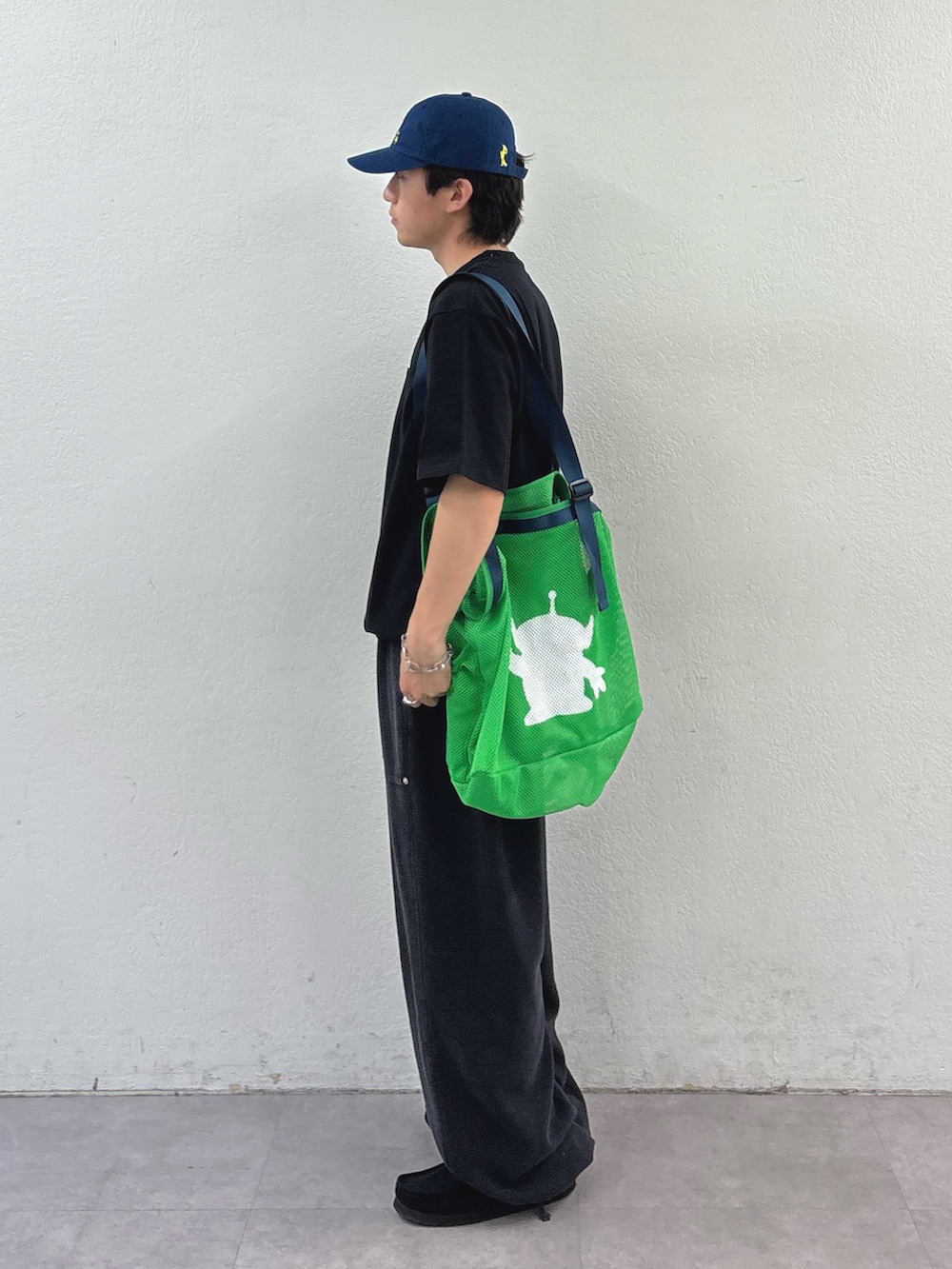 ブラック系のTシャツ/カットソー、グリーン系のトートバッグ、ブラック系のスウェットパンツを着用したメンズの春コーディネートの2枚目の写真