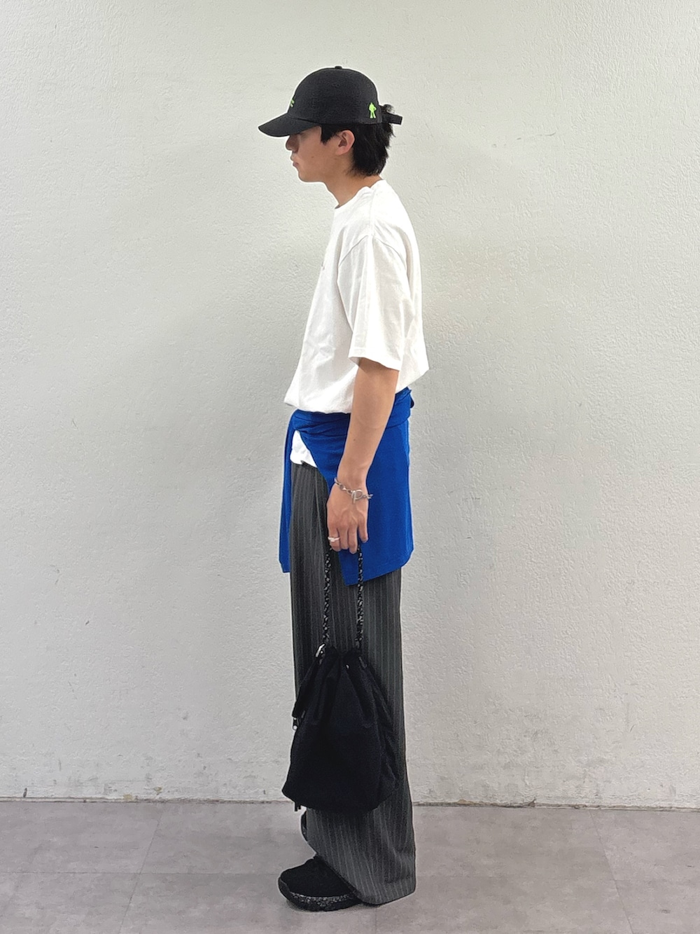 ホワイト系のTシャツ/カットソー、ブルー系のTシャツ/カットソー、グレー系のスラックスを着用したメンズの春コーディネートの2枚目の写真