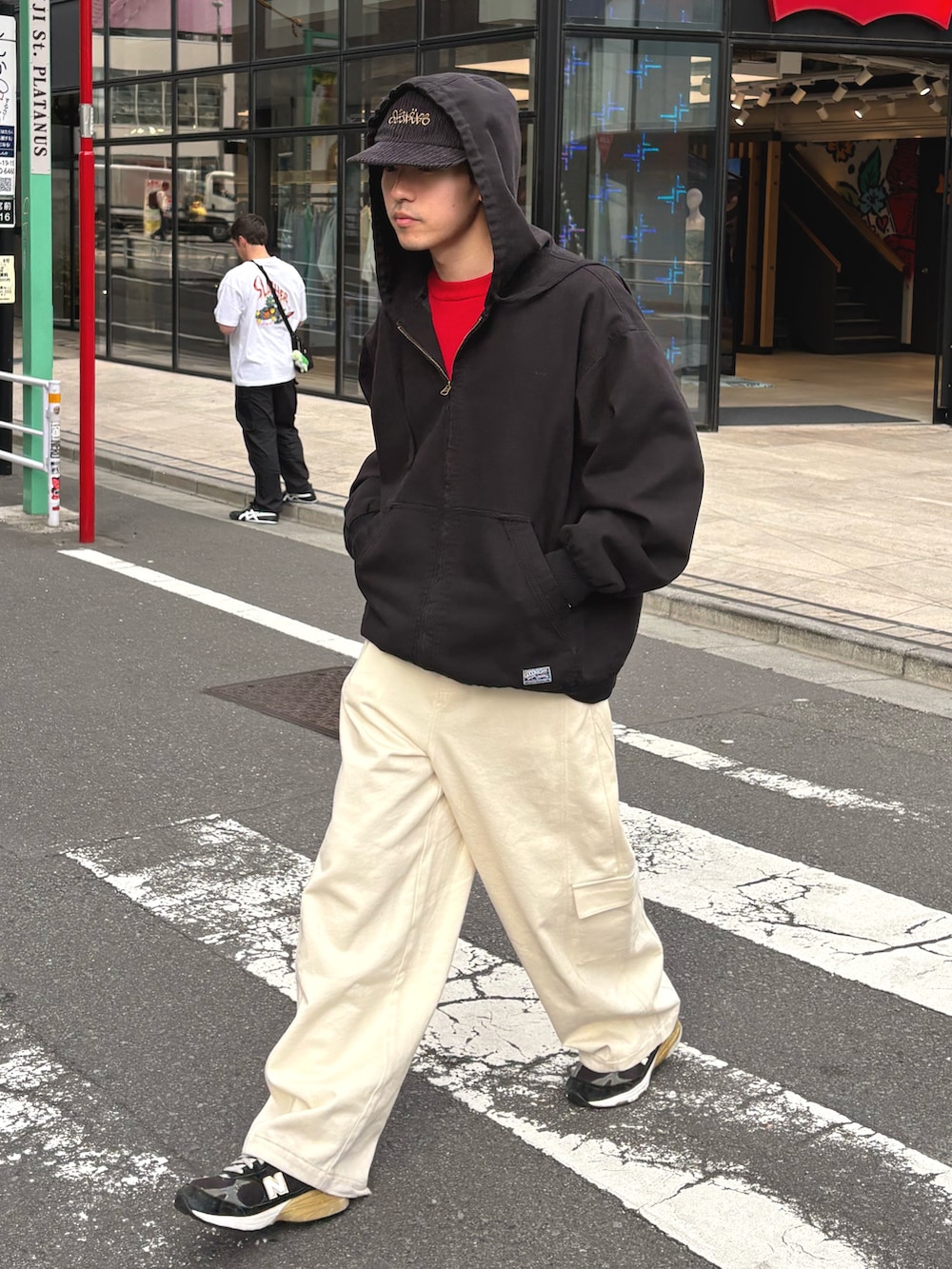 ブラック系のデニムジャケット、レッド系のニット/セーター、ホワイト系のカーゴパンツを着用したメンズの冬コーディネートの2枚目の写真