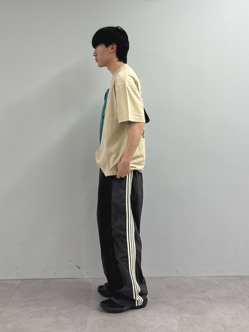 グレー系のスウェットパンツ、ベージュ系のTシャツ/カットソーを着用したメンズの春コーディネートの3枚目の写真