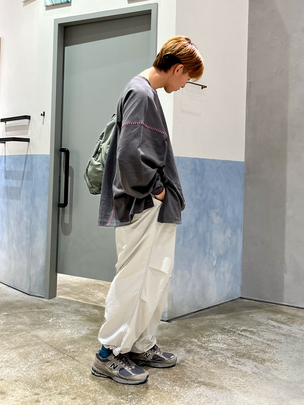 グレー系のスニーカー、グレー系のカーゴパンツ、グレー系のTシャツ/カットソーを着用したメンズの秋コーディネートの2枚目の写真