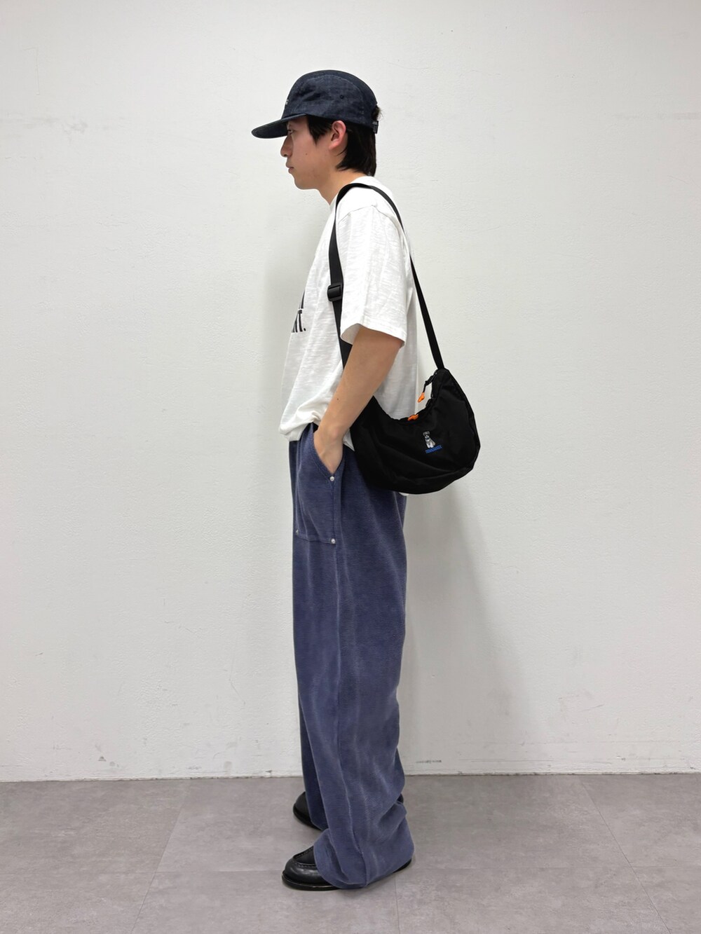 ホワイト系のTシャツ/カットソー、ブラック系のショルダーバッグ、ブルー系のスウェットパンツを着用したメンズの春コーディネートの2枚目の写真
