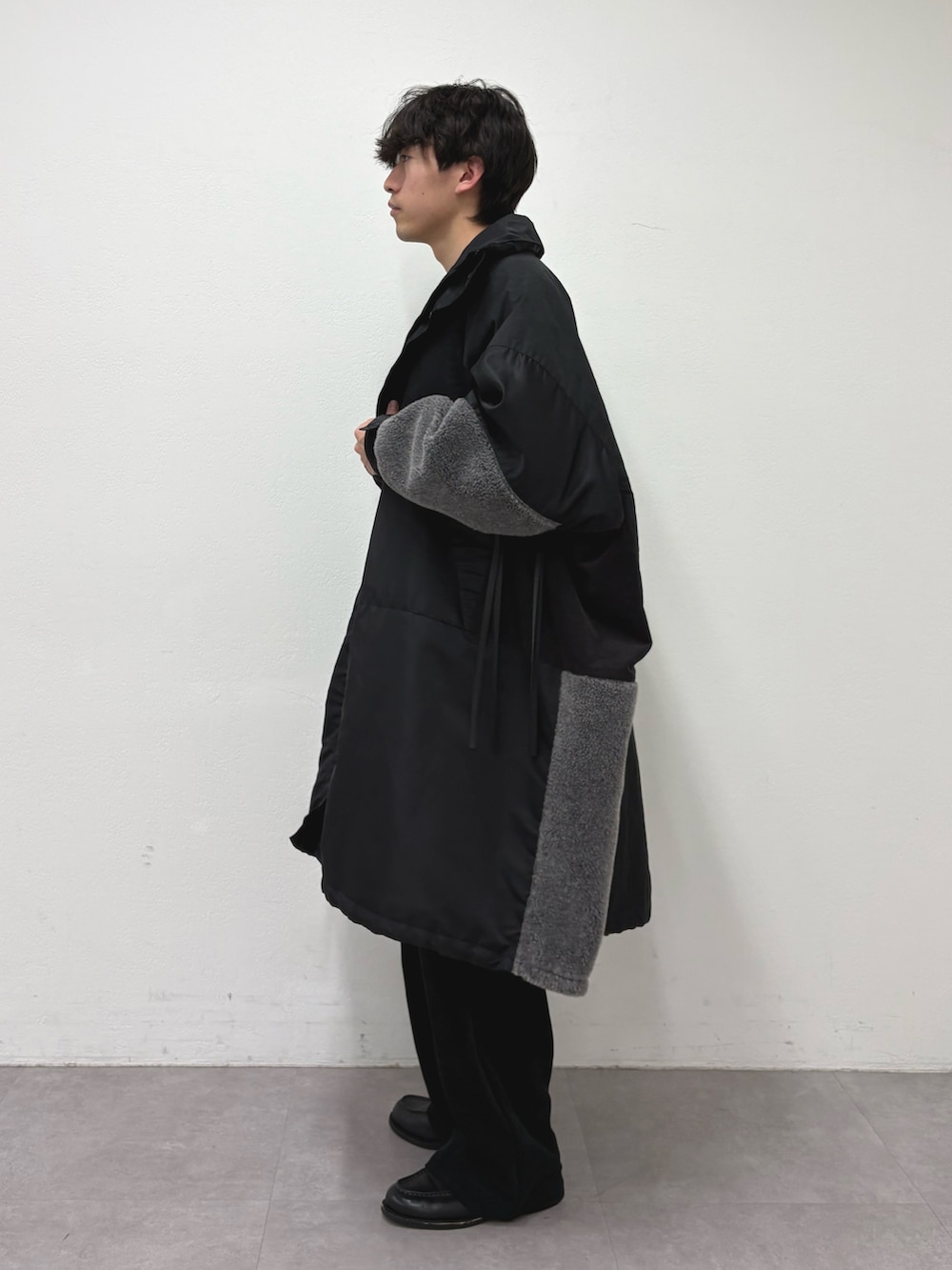 ブラック系のモッズコート、グレー系のニット/セーター、ブラック系のその他パンツを着用したメンズの冬コーディネートの2枚目の写真