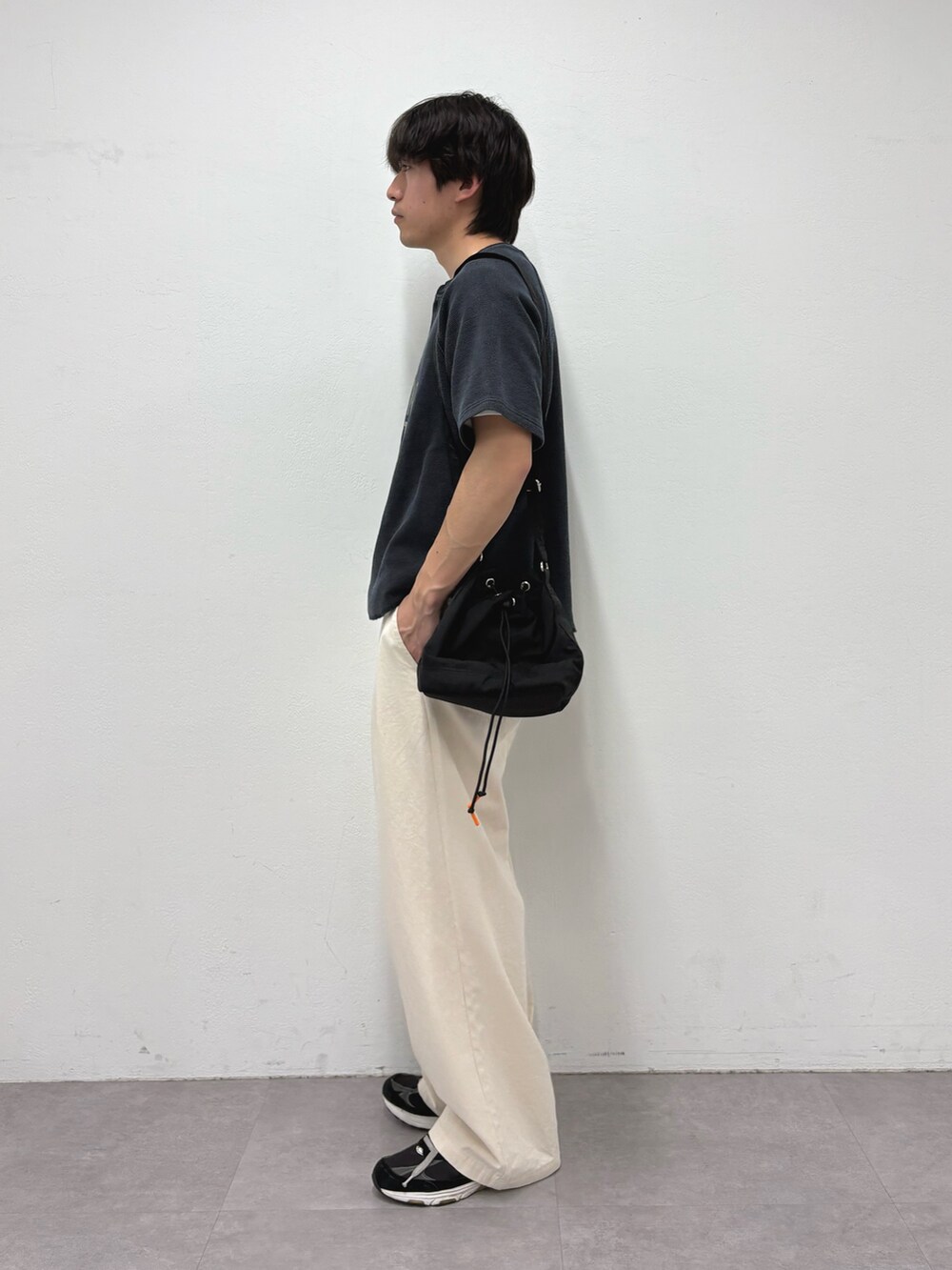 ブラック系のTシャツ/カットソー、ブラック系のショルダーバッグ、ホワイト系のデニムパンツを着用したメンズの春コーディネートの2枚目の写真
