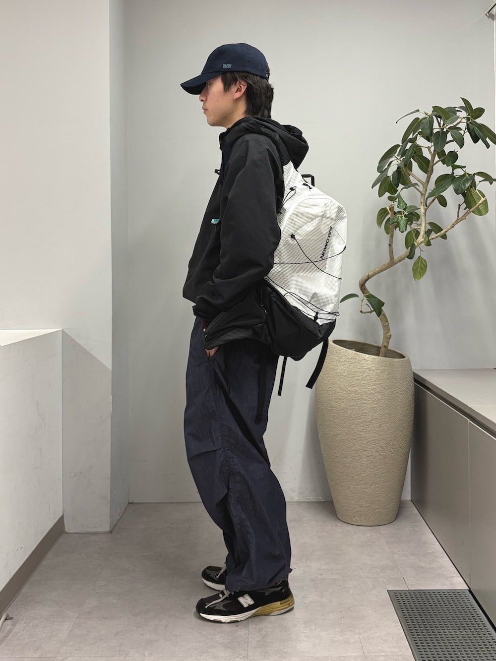 ブラック系のマウンテンパーカー、レッド系のニット/セーター、ブルー系のその他パンツを着用したメンズの冬コーディネートの2枚目の写真