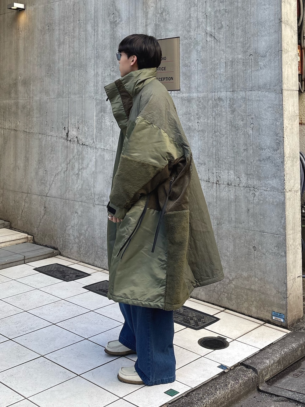 グリーン系のモッズコート、ブルー系のデニムパンツを着用したメンズの秋コーディネートの2枚目の写真