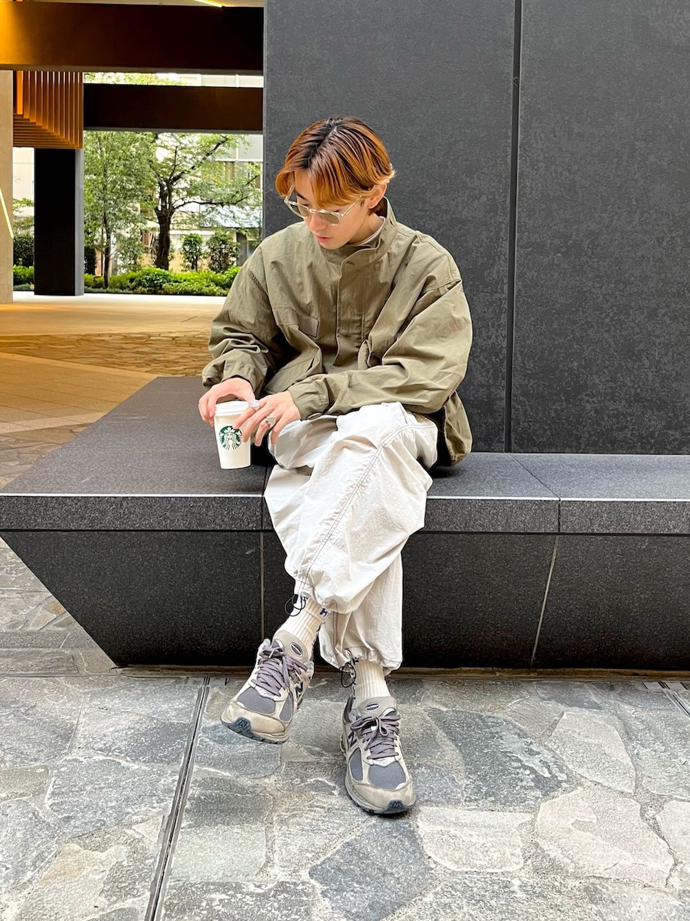 グレー系のスニーカー、グレー系のカーゴパンツ、グリーン系のモッズコートを着用したメンズの秋コーディネートの3枚目の写真