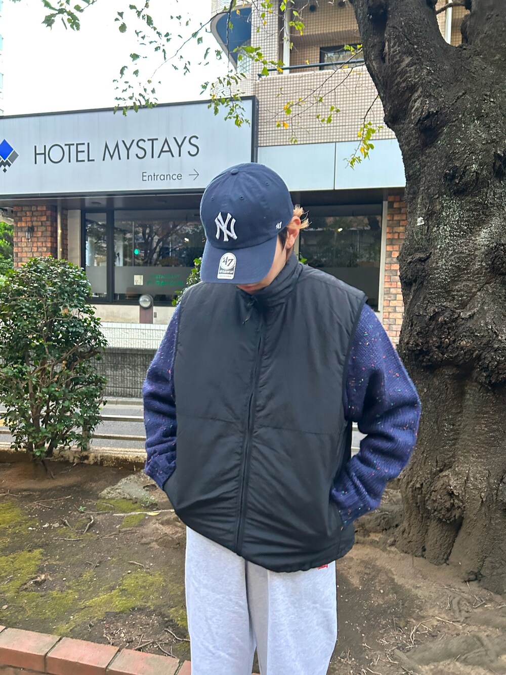 ホワイト系のスニーカー、グレー系のスウェットパンツ、ブラック系のベストを着用したメンズの冬コーディネートの3枚目の写真