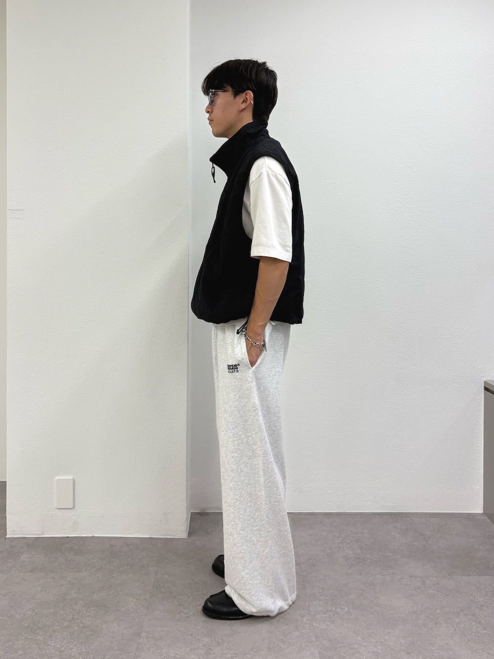 ブラック系のベスト、グレー系のスウェットパンツを着用したメンズの秋コーディネートの2枚目の写真