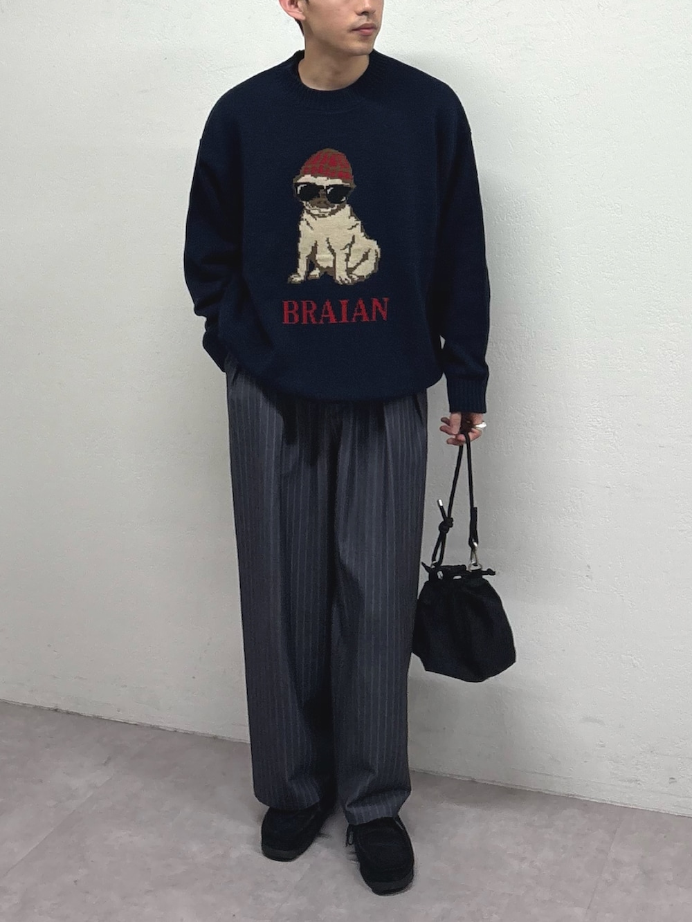 ブルー系のニット/セーター、グレー系のスラックス、ブラック系のショルダーバッグを着用したメンズの冬コーディネートの2枚目の写真