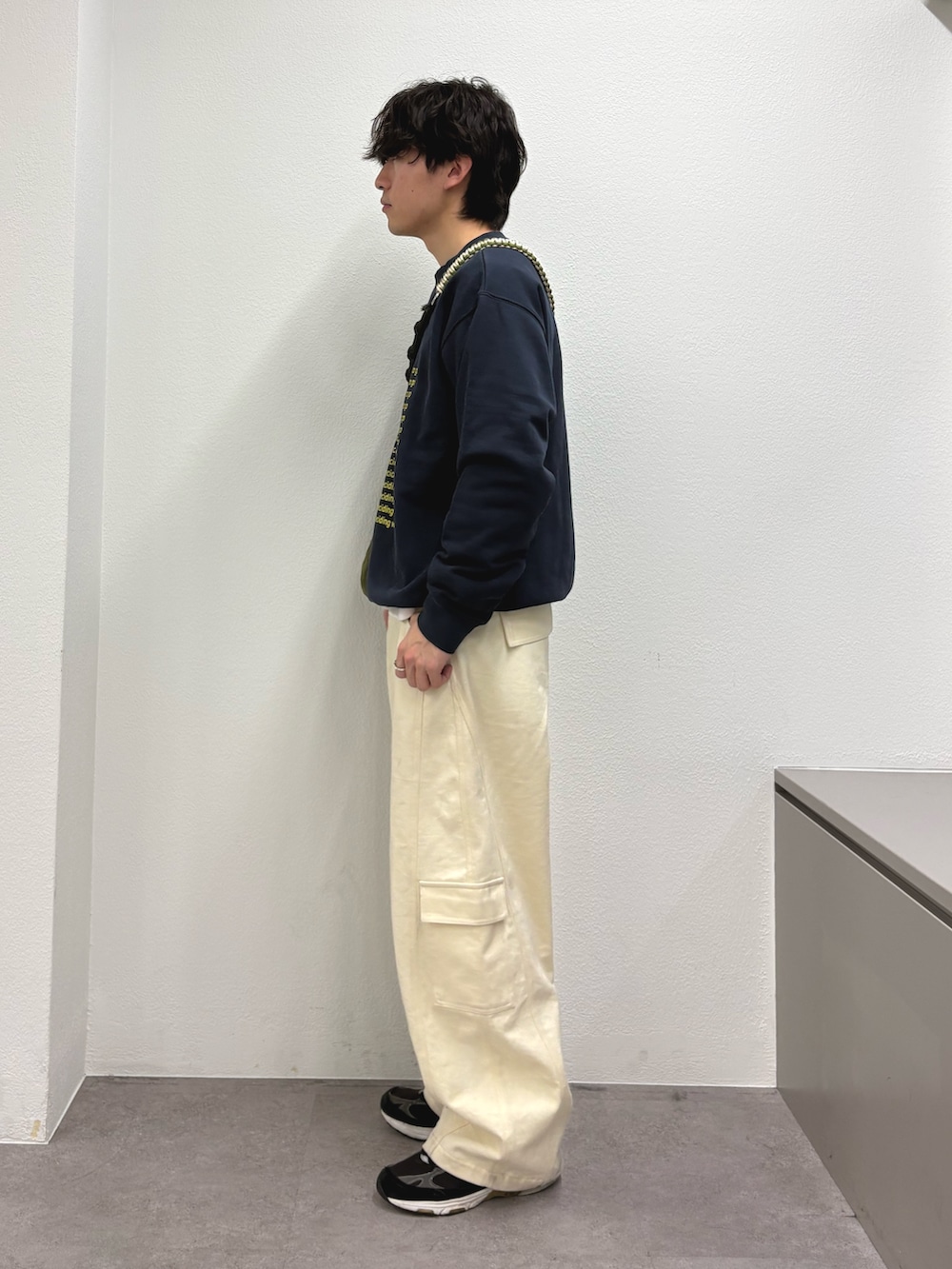 イエロー系のスウェット、ホワイト系のカーゴパンツを着用したメンズの冬コーディネートの2枚目の写真