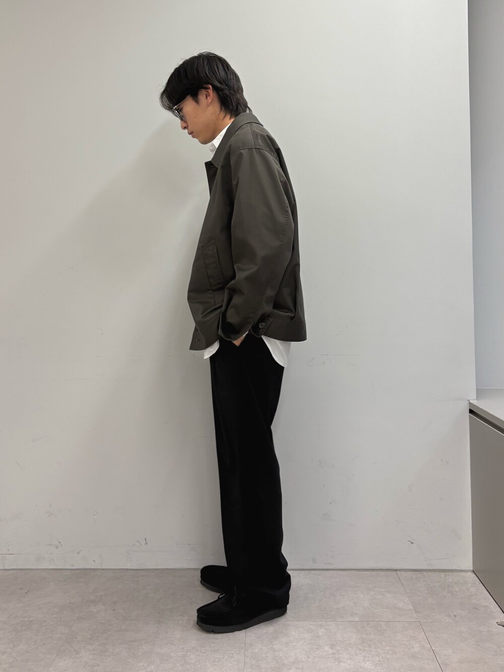 ホワイト系のシャツ/ブラウス、グレー系のブルゾン、ブラック系のスラックスを着用したメンズの春コーディネートの2枚目の写真