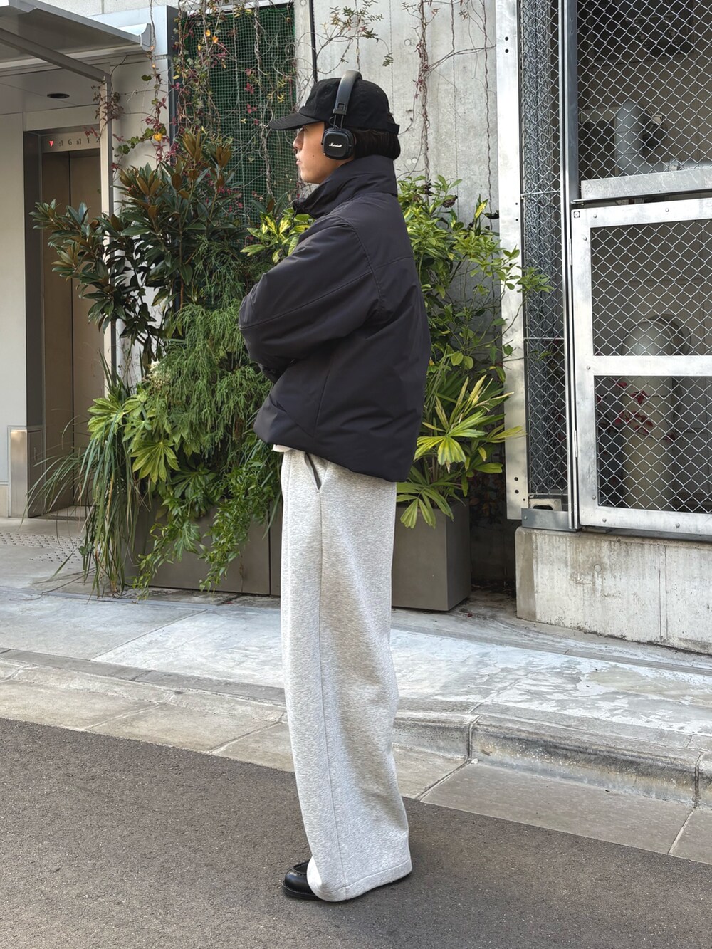 ブラック系のダウンジャケット/コート、グレー系のその他パンツ、ブラック系のキャップを着用したメンズの冬コーディネートの2枚目の写真