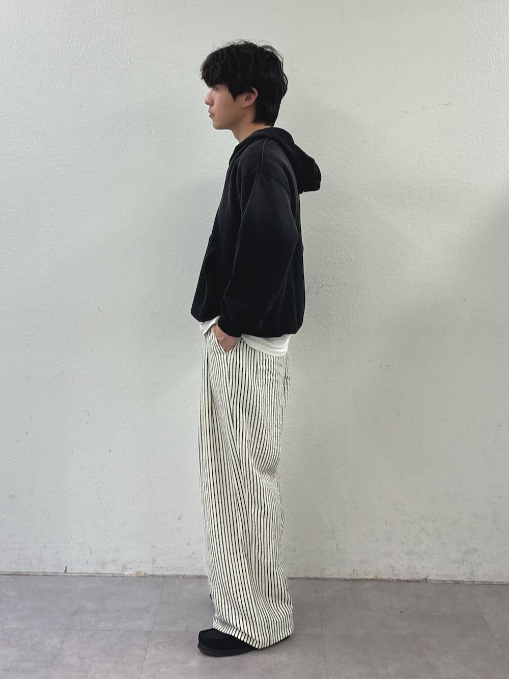 ブラック系のパーカー、ホワイト系のその他パンツを着用したメンズの春コーディネートの2枚目の写真