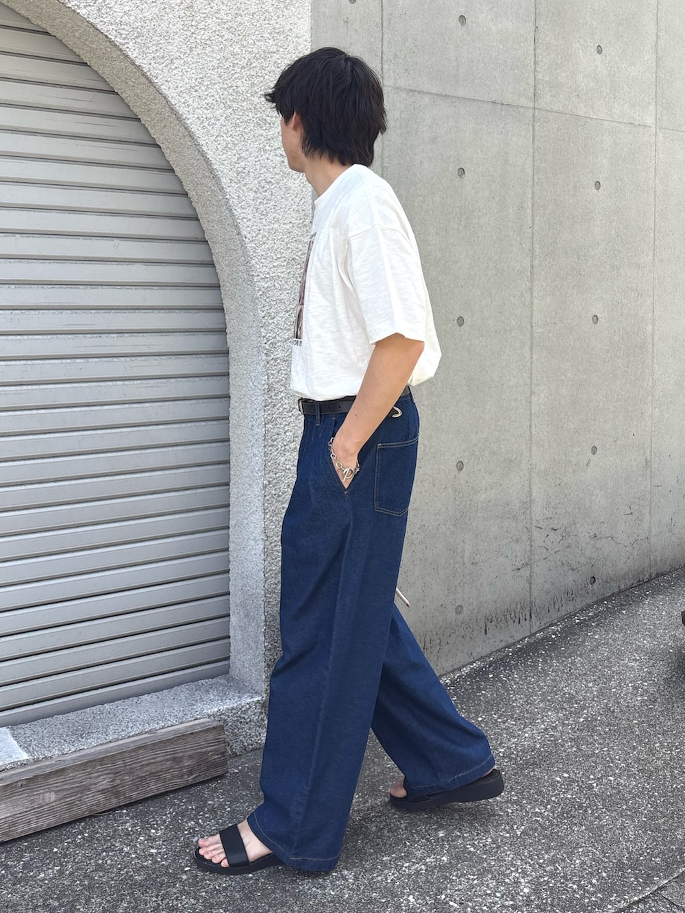 ホワイト系のTシャツ/カットソー、レッド系のショルダーバッグ、ブルー系のデニムパンツを着用したメンズの春コーディネートの2枚目の写真
