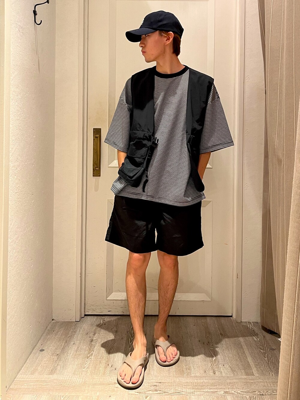 ブラック系のベスト、ブラック系のTシャツ/カットソー、ブラック系のパンツを着用したメンズの夏コーディネートの2枚目の写真