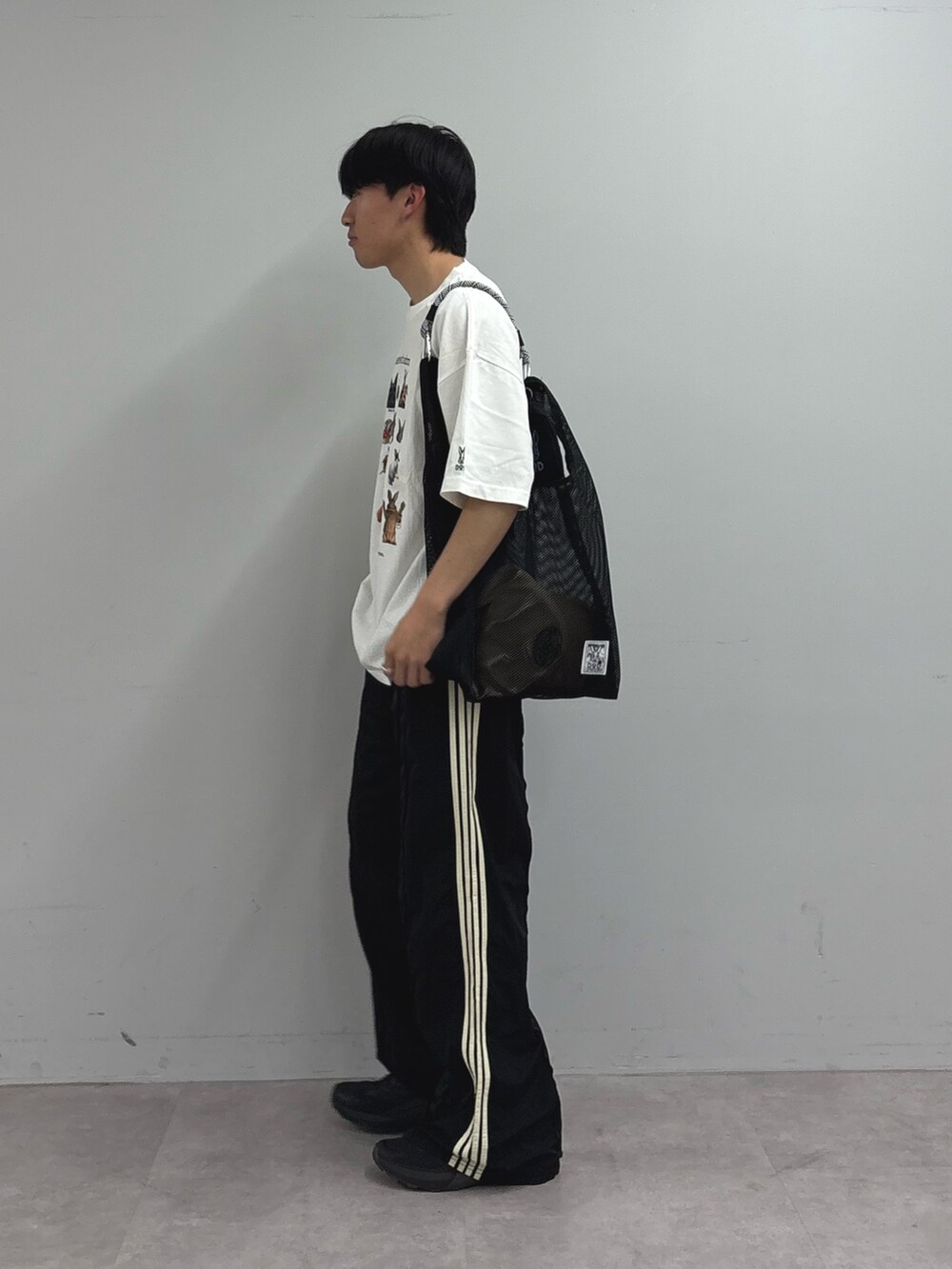 ホワイト系のTシャツ/カットソー、ブラック系のトートバッグ、ブラック系のスウェットパンツを着用したメンズの春コーディネートの2枚目の写真