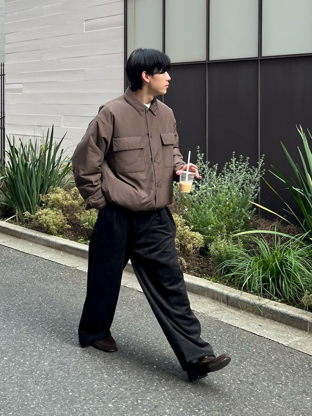 ブラウン系のブルゾン、ブラック系のスラックス、ブラウン系のローファーを着用したメンズの秋コーディネートの2枚目の写真