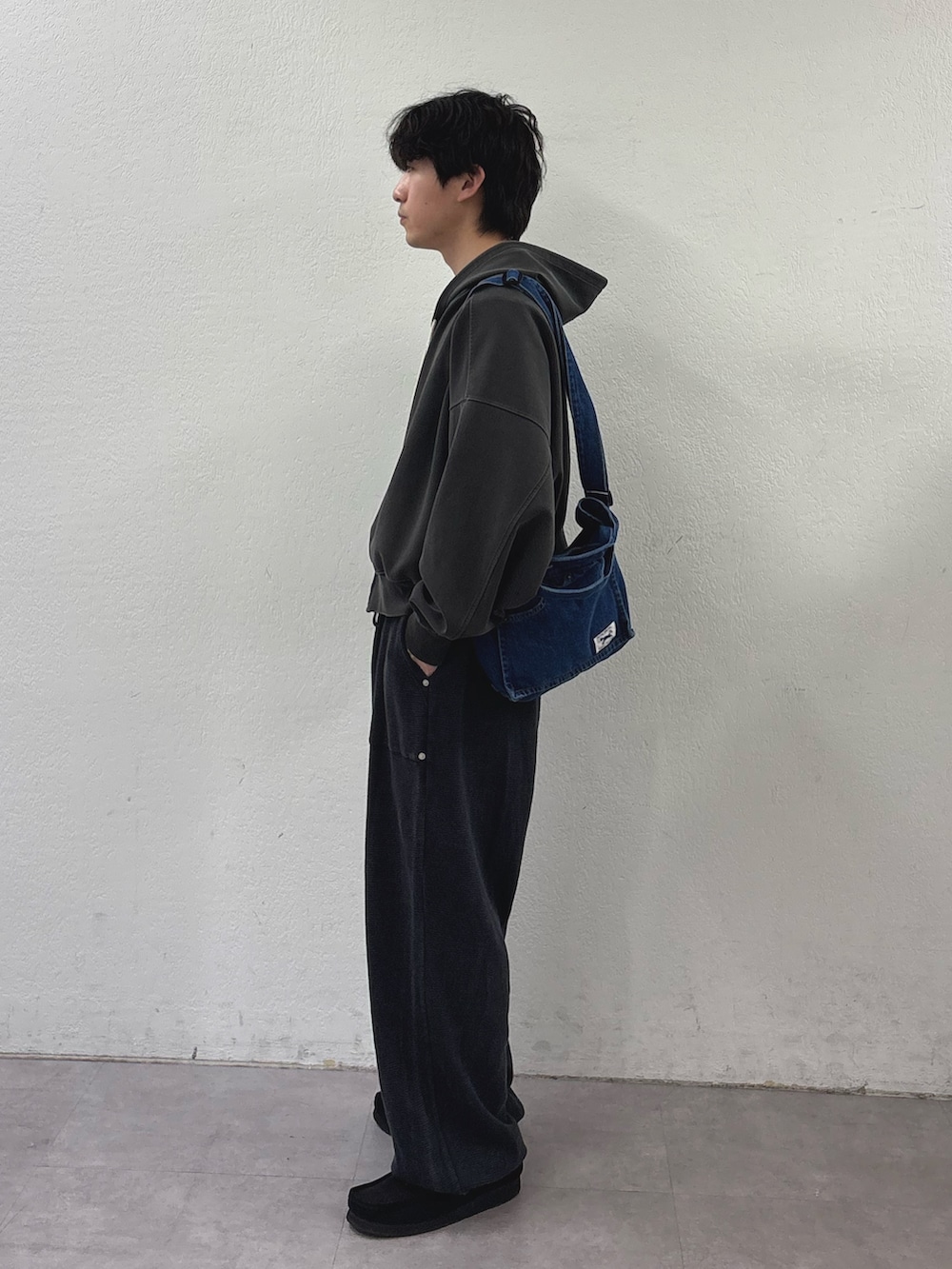 ブルー系のショルダーバッグ、グレー系のパーカー、ブラック系のスウェットパンツを着用したメンズの春コーディネートの2枚目の写真