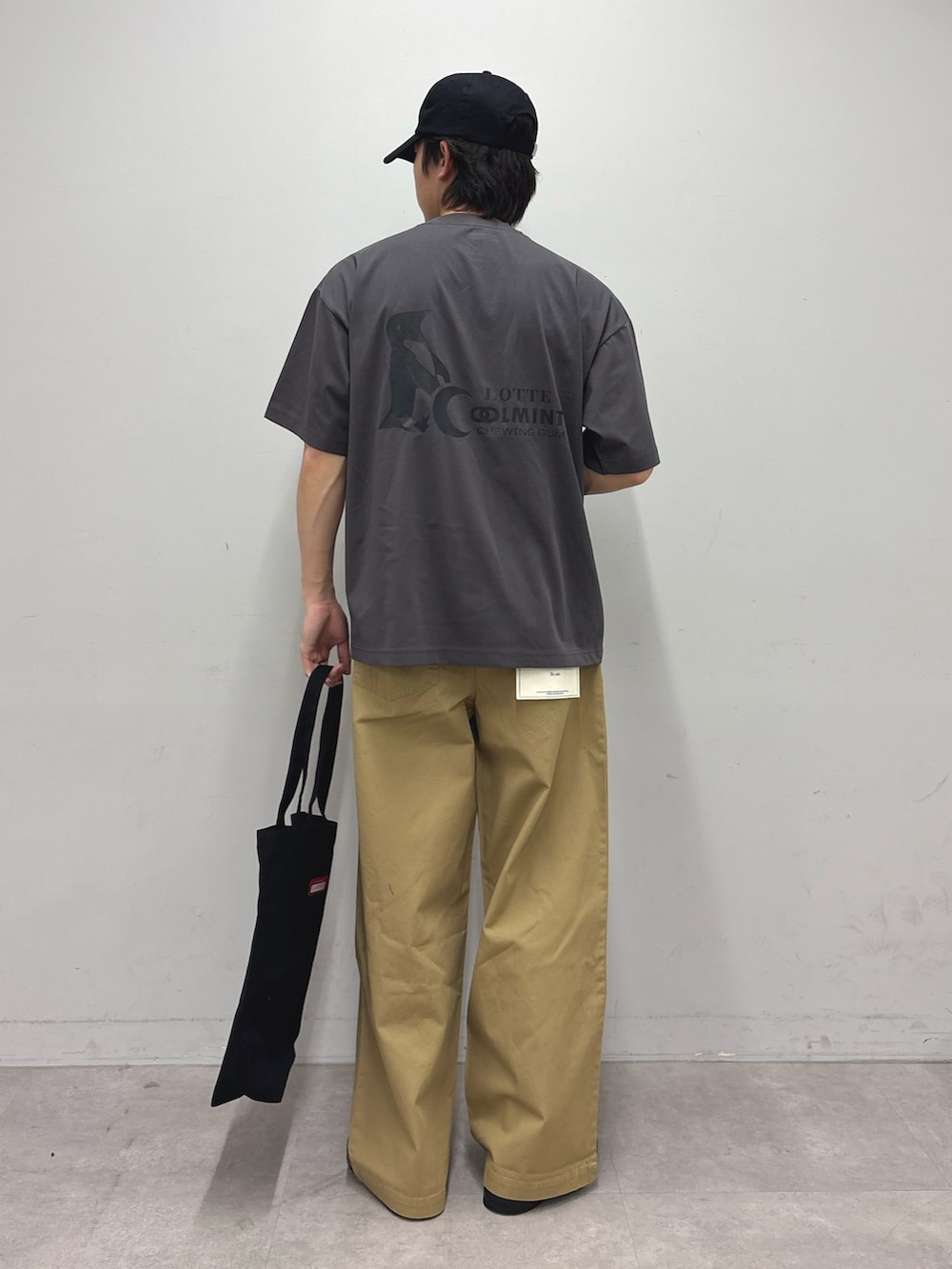 グレー系のTシャツ/カットソー、ベージュ系のデニムパンツ、ブラック系のトートバッグを着用したメンズの春コーディネートの3枚目の写真