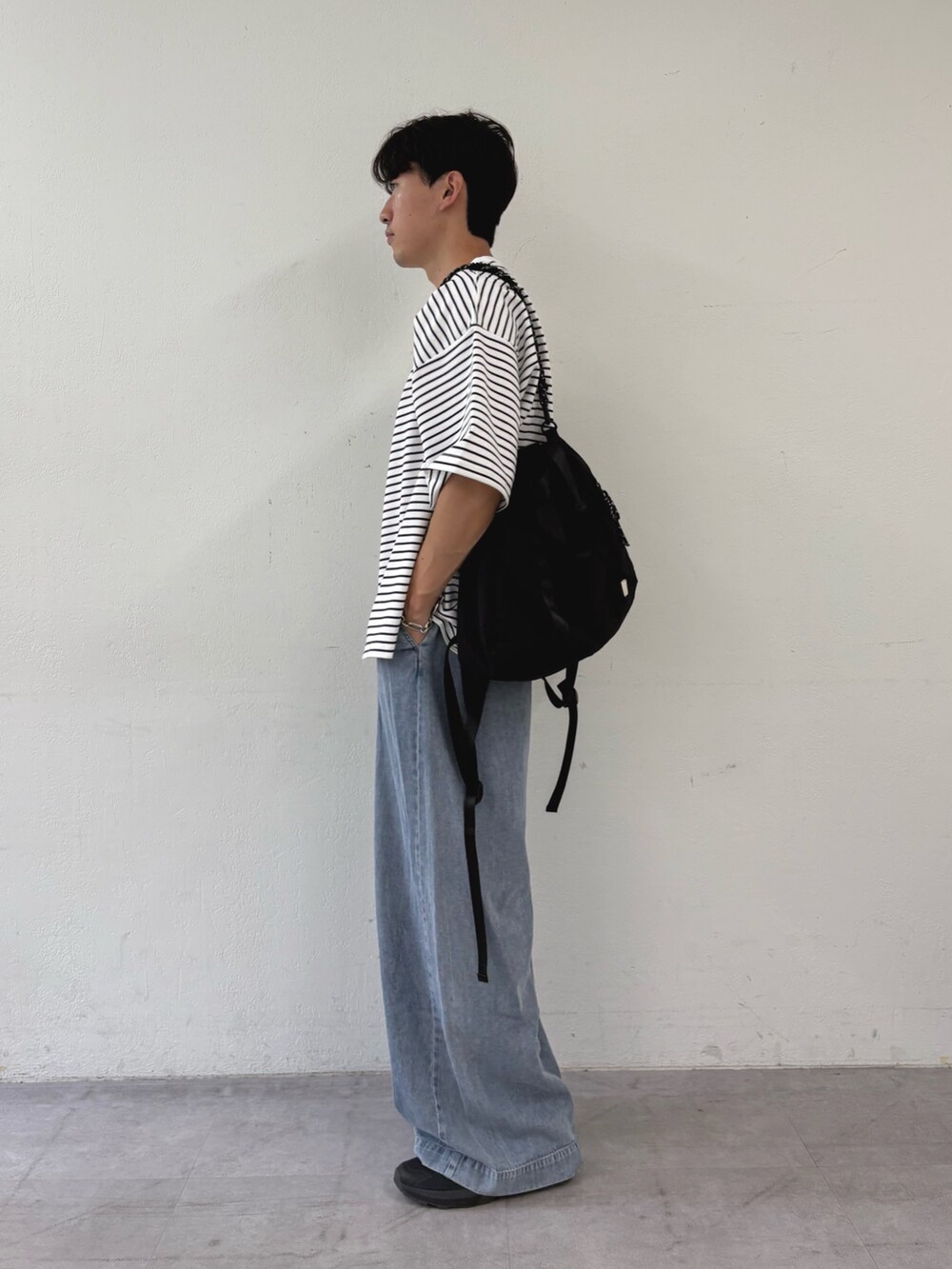 ホワイト系のTシャツ/カットソー、ブルー系のデニムパンツ、ブラック系のトートバッグを着用したメンズの秋コーディネートの2枚目の写真