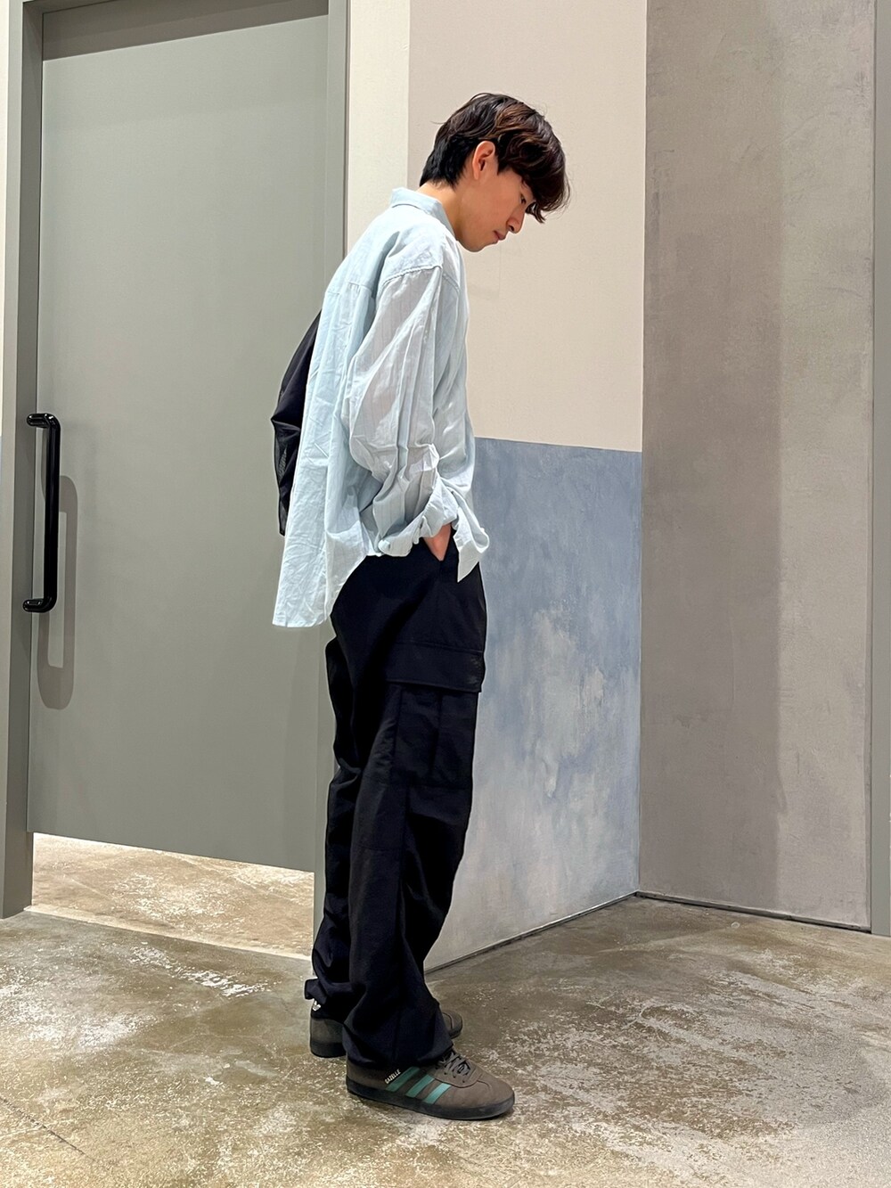 グレー系のスニーカー、ブラック系のカーゴパンツ、ホワイト系のタンクトップを着用したメンズの夏コーディネートの3枚目の写真