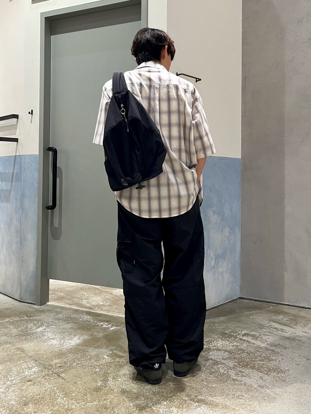 グレー系のスニーカー、ブラック系のカーゴパンツ、グレー系のシャツ/ブラウスを着用したメンズの夏コーディネートの3枚目の写真